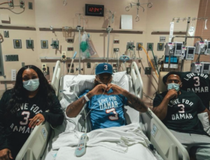 Damar Hamlin makes a heart sign with his hands while in the hospital for recovery after experiencing sudden cardiac arrest.
